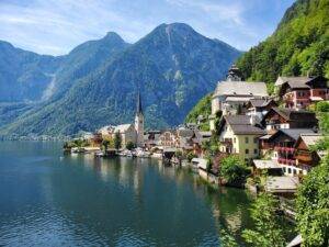 houses near body of water and mountain during daytime