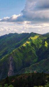 green mountain under white clouds during daytime