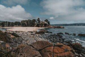 a rocky beach with a small island in the background