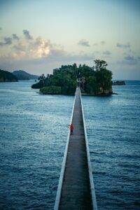 a person standing on a pier in the middle of a body of water