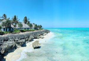 rocky beach with white cottages under clear blue sky